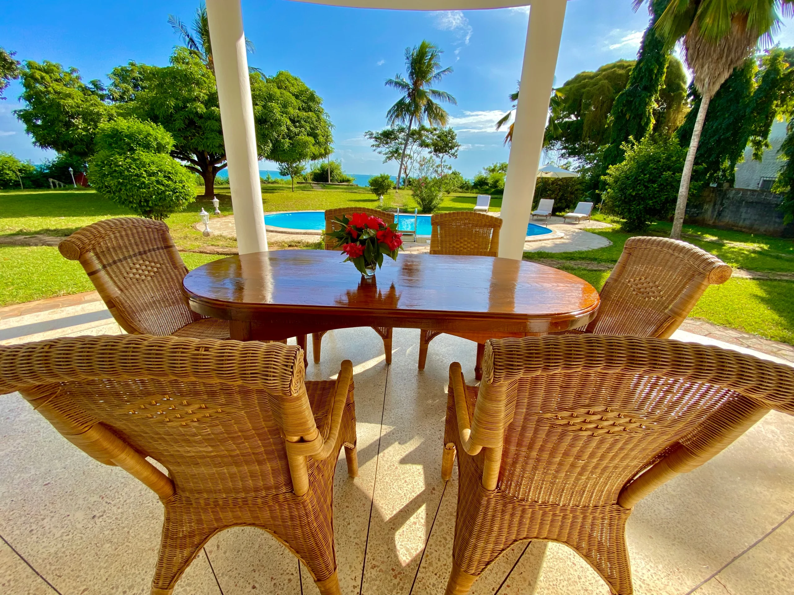 Outdoor dining area at Villa Heidi Zanzibar overlooking pool and tropical garden